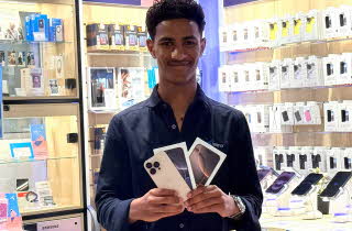 Mann holder Apple iPhone mobiltelefoner fra Telenorbutikken