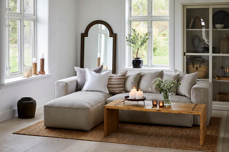 stue med sofa, stuebord, diverse duftlys og stearinlys