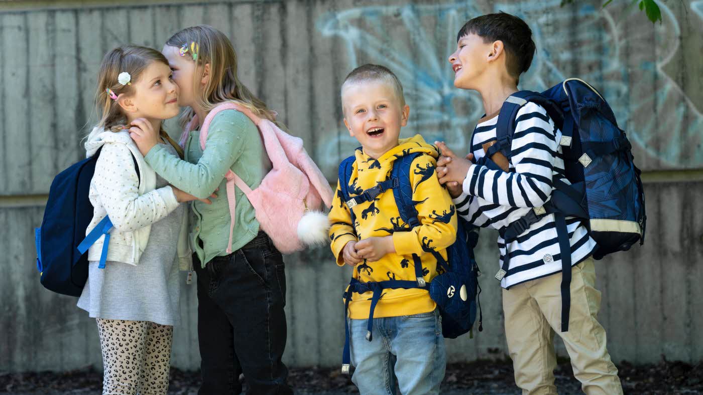 4 skolebarn står sammen og prater