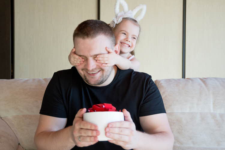 liten jente som holder for øynene på pappaen sin