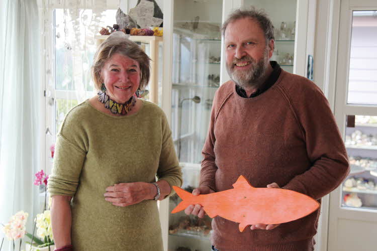 Kvinne i grønn genser og mann som holder oransje tre-fisk