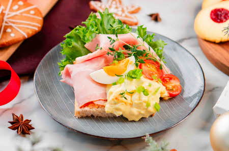 En asjett med et smørbrød med juleskinke og eggesalat