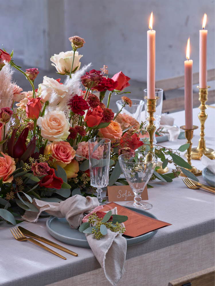 Dekorert bord til bryllup med oransje blomster