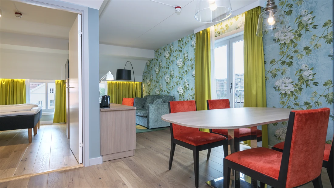 Bord og stoler, sofagruppe og separat soverom i suiten på Thon Hotel Tønsberg Brygge