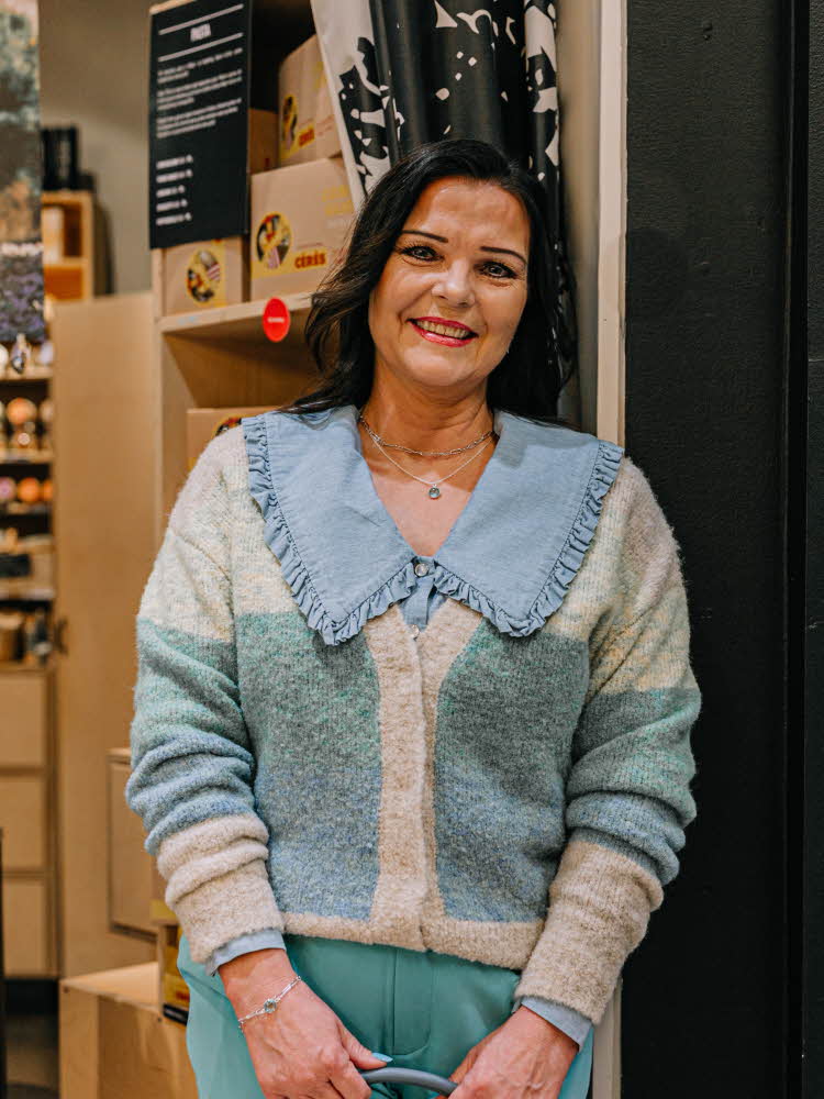 Dame i strikket genser og dressbukser