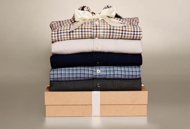 Stabel med fem flanellskjorter i ulike farger og mønstre.