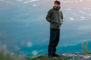 En mann som står på en ås med fantastisk utsikt bak han