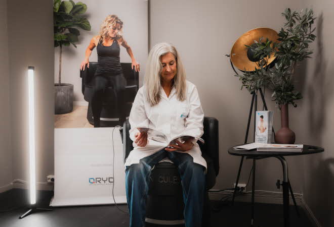 dame med hvit frakk som sitter i en stol