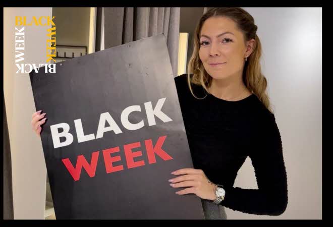 En dame som holder en Black Week-plakat