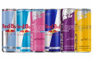Seks Red Bull-bokser i ulike farger og smaker, inkludert original, sukkerfri og flere fruktvarianter.