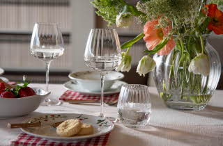 Et bord dekket til middag, med en store vase med blomster