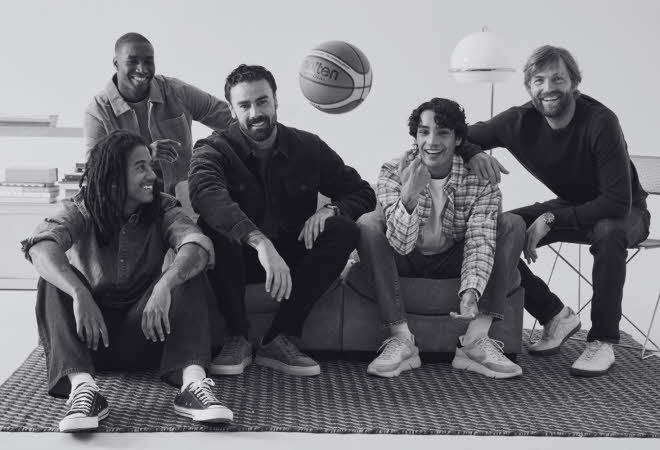 Svart-hvitt bilde av fem menn som sitter i en sofa med en basketball.