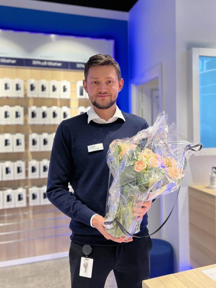 Mann som holder bukett med blomster i Telenor butikken