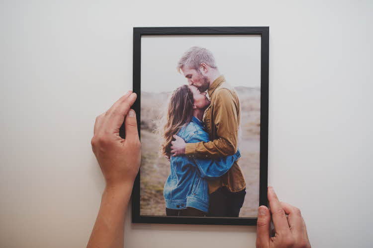 Dame som holder et foto i en ramme