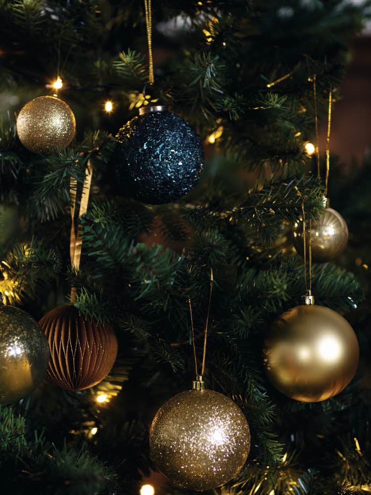 Nærbilde av et juletre med julekuler i blått og gull