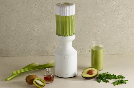 En Beast blender med avokado og kiwi ved siden av.