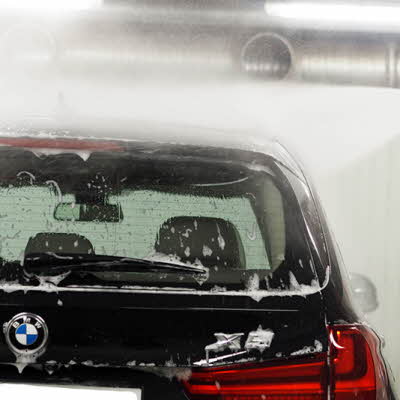 Mann spyler taket på en BMW