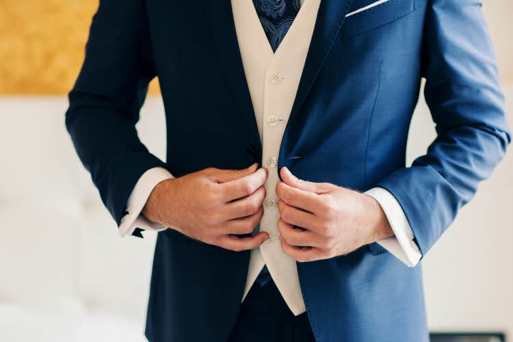 Mann i mørkeblå dress med hvit vest under