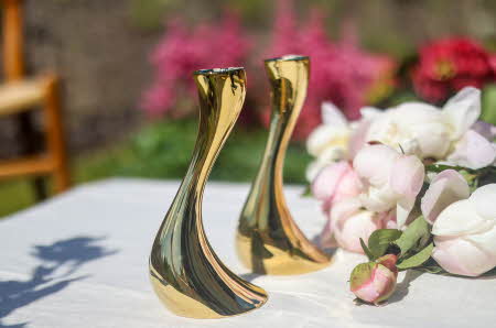 To Cobra lysestaker fra Georg Jensen som står på et bord ute med en bukett ved siden av
