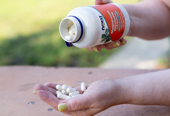 Et par hender som heller magnesium tabletter fra en eske ut i den andre hånden
