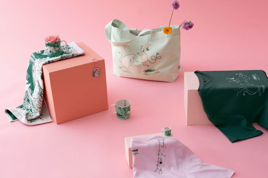 Rosa bakgrunn med diverse Mummiprodukter som ligger på bokser.