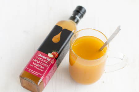 flaske med juice og juice i en gjennomsiktig kopp