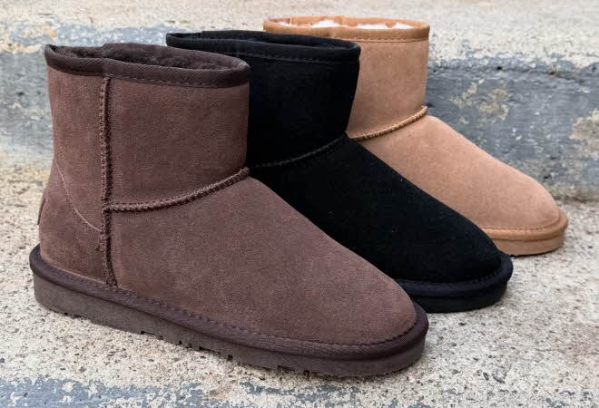 Støvler i brun, sort og beige står på en grå steintrapp