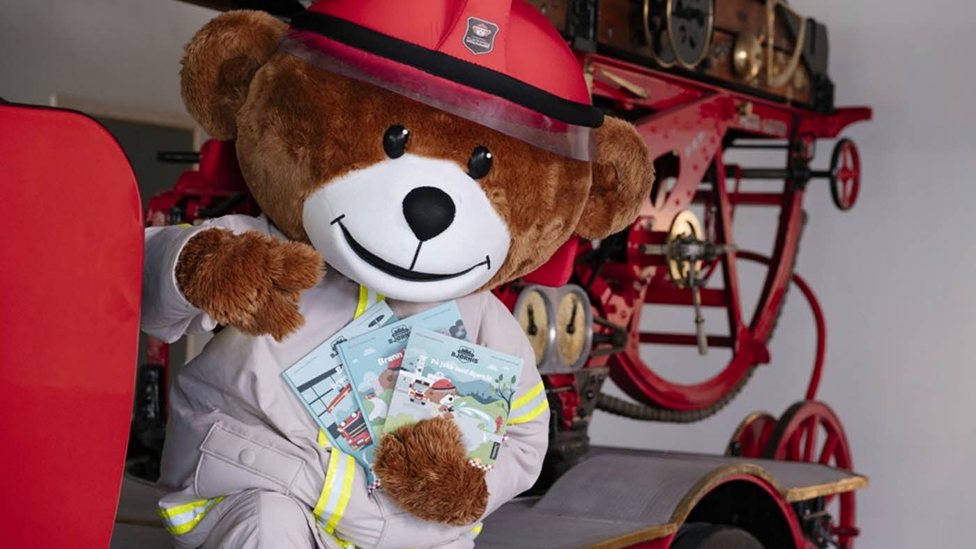 Maskot i bamse på en brannbil