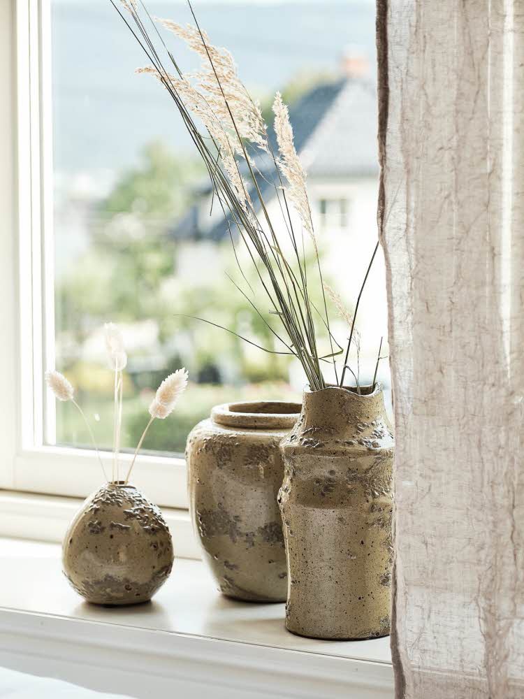 bilde av vaser i en vinduskarm bilde fra kjøkkenbenk med krydder, gryn, urter og skjærefjøler bilde av oppredd seng med sengeteppe og fine puter