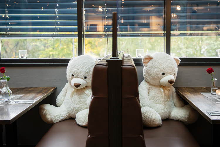 Bilde av store teddybjørner ved restaurantbord
